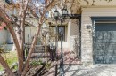 Front exterior with light-colored horizontal siding, a dark garage door, and decorative wrought iron accents - 1764 Melrose Crescent, Edmonton, AB 