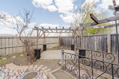 Backyard featuring a wooden pergola, a raised wood-finish deck, and a privacy fence - 1764 Melrose Crescent, Edmonton, AB 