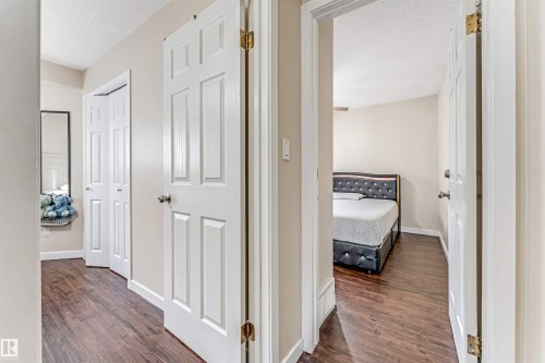 Hallway featuring wood-finish flooring, light-toned wall paint, and white trim - 1529 49A Street Nw, Edmonton, AB - Indoor Photo Showing Other Room