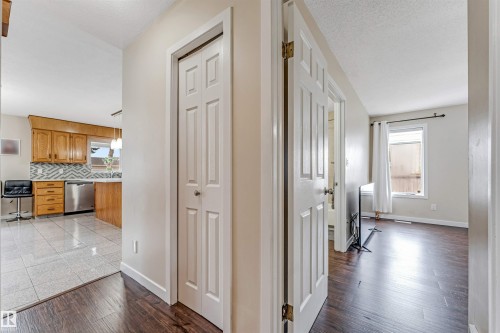 Hallway featuring dark wood-finish flooring, white paneled doors, and light neutral wall paint - 1529 49A Street Nw, Edmonton, AB - Indoor Photo Showing Other Room