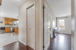 Hallway featuring dark wood-finish flooring, white paneled doors, and light neutral wall paint - 