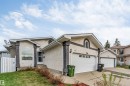 Stucco exterior with decorative stone accents, arched window, and attached double garage - 1529 49A Street Nw, Edmonton, AB  - Outdoor 