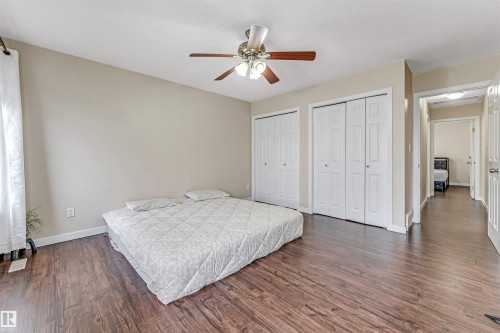 Spacious room featuring wood-finish flooring, light neutral wall paint, and a ceiling fan with integrated lighting - 1529 49A Street Nw, Edmonton, AB - Indoor Photo Showing Bedroom