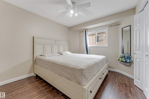 Spacious room featuring wood-finish flooring, a ceiling fan with integrated lighting, and a window with blinds - 1529 49A Street Nw, Edmonton, AB - Indoor Photo Showing Bedroom