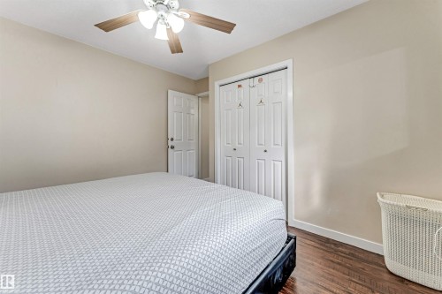 Bedroom featuring wood-finish flooring, neutral wall tones, and a ceiling fan with integrated lighting - 1529 49A Street Nw, Edmonton, AB - Indoor Photo Showing Bedroom