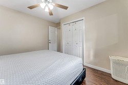 Bedroom featuring wood-finish flooring, neutral wall tones, and a ceiling fan with integrated lighting - 