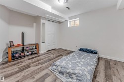 Spacious room featuring wood-finish flooring, white baseboards, and a white ceiling - 