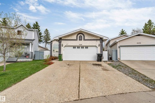 Stucco and stone facade home featuring an arched entryway and an attached two-car garage - 1529 49A Street Nw, Edmonton, AB - Outdoor With Facade