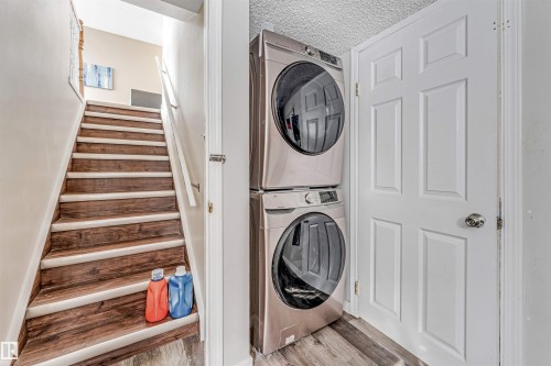 Dedicated laundry area featuring stacked front-loading washer and dryer units - 1529 49A Street Nw, Edmonton, AB - Indoor Photo Showing Laundry Room