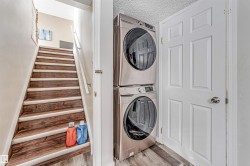 Dedicated laundry area featuring stacked front-loading washer and dryer units - 