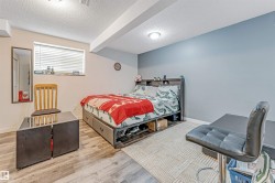 Spacious room featuring light wood-finish flooring, a neutral wall color with an accent wall, and a recessed window with blinds - 