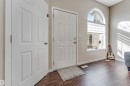 Entryway featuring wood-finish flooring, a white six-panel door, and an arched window with integrated blinds - 1529 49A Street Nw, Edmonton, AB  - Indoor Photo Showing Other Room 