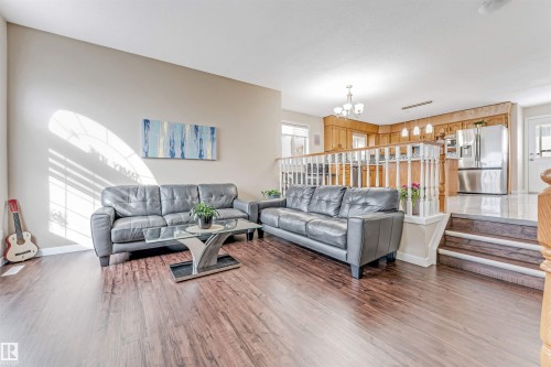 Open-concept living area featuring wood-finish flooring, neutral wall tones, and a multi-level design - 1529 49A Street Nw, Edmonton, AB - Indoor Photo Showing Living Room