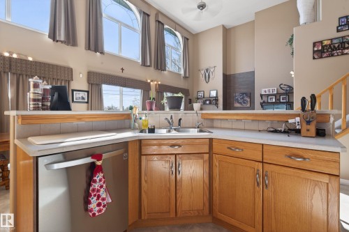 Kitchen featuring light wood cabinetry, light-toned countertops, and a stainless steel dishwasher - 21 Pipestone Drive, Devon, AB - Indoor Photo Showing Kitchen With Double Sink
