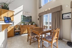 Dining area featuring high ceilings, light-toned wall paint, and a sliding glass door with a transom window - 