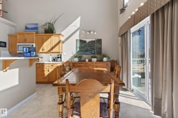 Dining area featuring a wood-finish table, high ceilings, and a sliding glass door with balcony access - 