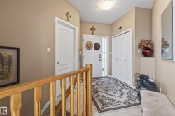 Entryway featuring a light wood-finish banister, a white paneled door, and a white bi-fold closet door - 