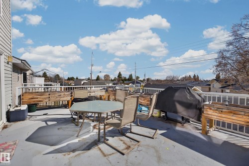 Spacious elevated deck with white railing, featuring a neutral-toned composite surface and exterior wall siding - 21 Pipestone Drive, Devon, AB - Outdoor With Deck Patio Veranda