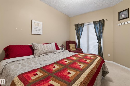 Bedroom featuring neutral wall paint, carpet flooring, a window with blinds, and decorative curtain rods - 21 Pipestone Drive, Devon, AB - Indoor Photo Showing Bedroom