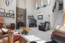 Living space featuring a vaulted ceiling with decorative ledges, light neutral wall colors, and wall-mounted shelving - 21 Pipestone Drive, Devon, AB  - Indoor Photo Showing Other Room 