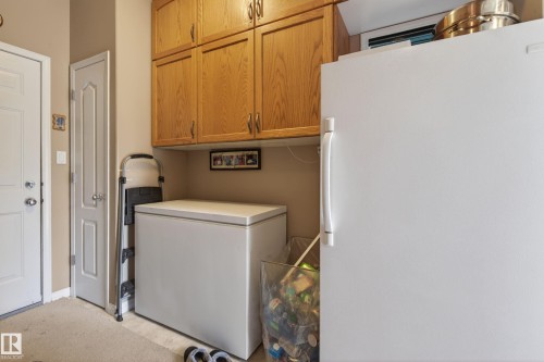 Light wood-finish cabinetry provides overhead storage - 21 Pipestone Drive, Devon, AB - Indoor Photo Showing Laundry Room