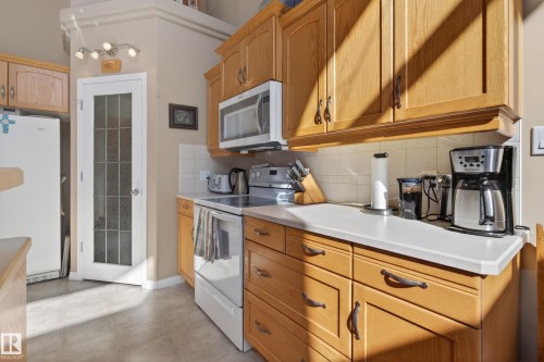Kitchen featuring light wood cabinetry and light-toned countertops - 21 Pipestone Drive, Devon, AB - Indoor Photo Showing Kitchen