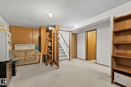 Carpeted lower level with wood paneling and painted walls - 4707 10A Avenue, Edmonton, AB 