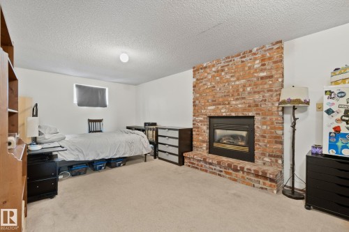 Brick-front fireplace with a black insert and a raised hearth - 4707 10A Avenue, Edmonton, AB 