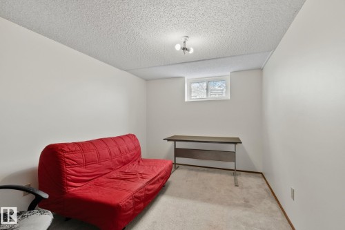 Carpeted room featuring a single window, white walls, and a textured ceiling - 4707 10A Avenue, Edmonton, AB 