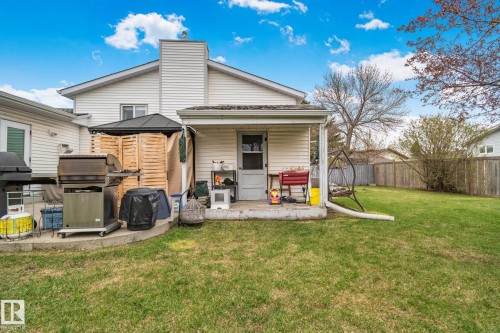 Spacious backyard featuring a large grass area and a concrete patio - 4707 10A Avenue, Edmonton, AB 