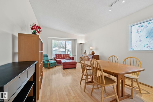Open-concept room featuring wood-finish flooring, vaulted ceilings, and a large dining area - 4707 10A Avenue, Edmonton, AB 