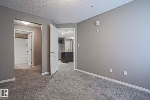 Carpeted interior space with neutral gray walls and white trim - 201 1520 Hammond Gate Gate, Edmonton, AB 
