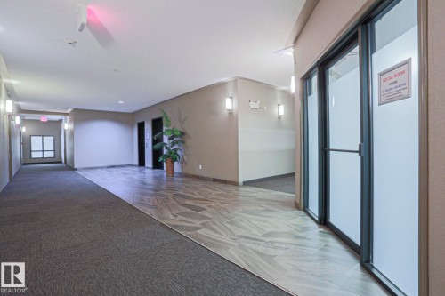Hallway featuring a combination of textured carpet and patterned tile flooring - 201 1520 Hammond Gate Gate, Edmonton, AB 