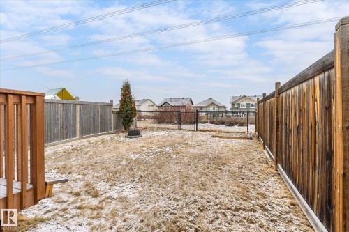 Fenced backyard featuring a wood deck with railings, a privacy fence, and a designated fire pit area - 1668 Chapman Way Sw, Edmonton, AB - Outdoor