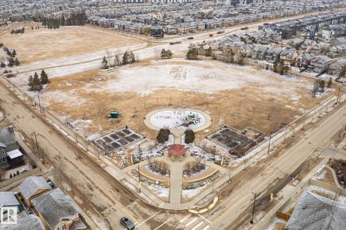 Expansive community park featuring a gazebo, central playground area, multiple garden plots, and paved walking paths - 1668 Chapman Way Sw, Edmonton, AB - 