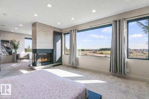 Huge Primary Bedroom featuring Private Sitting room with Wet Bar and Bar Fridge, Huge Ensuite Closet, Three Sided Fireplace, and Ensuite - 5536 Chegwin Point(E), Edmonton, AB - Indoor With Fireplace