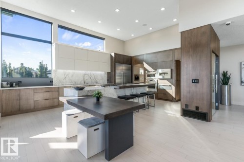 Stunning Kitchen featuring floor to ceiling windows with remote blinds, Gas Stove Top, Pizza Oven, Microwave Convection Oven, Oversized Refrigerator, Granite Counters, and Two Tone Cabinets. - 5536 Chegwin Point(E), Edmonton, AB - Indoor