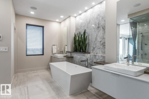 Primary 5 Piece Ensuite Bathroom featuring Glass Shower, Standalone Tub, Heated Floors, and Pass Through to Walk in Closet - 5536 Chegwin Point(E), Edmonton, AB - Indoor Photo Showing Bathroom