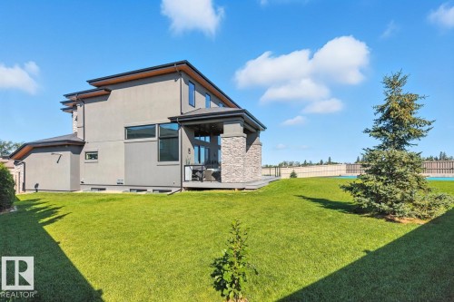 North East Facing Back yard featuring Covered Deck with Composite Boards, Ample Grass Space, Pickle Ball/Basketball Court, Fully Landscaped, and Fully Fenced. - 5536 Chegwin Point(E), Edmonton, AB - Outdoor