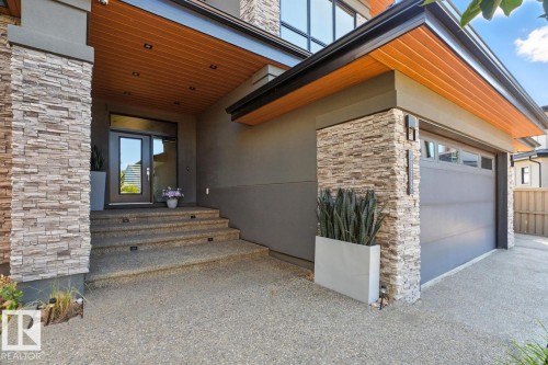 Exterior Front of House showing Oversized Driveway, Triple Car Garage, and Siding on to Walking Path - 5536 Chegwin Point(E), Edmonton, AB - Outdoor With Exterior