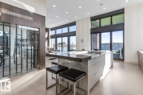 Stunning Kitchen featuring floor to ceiling windows with remote blinds, Gas Stove Top, Pizza Oven, Microwave Convection Oven, Oversized Refrigerator, Granite Counters, and Two Tone Cabinets. - 5536 Chegwin Point(E), Edmonton, AB - Indoor