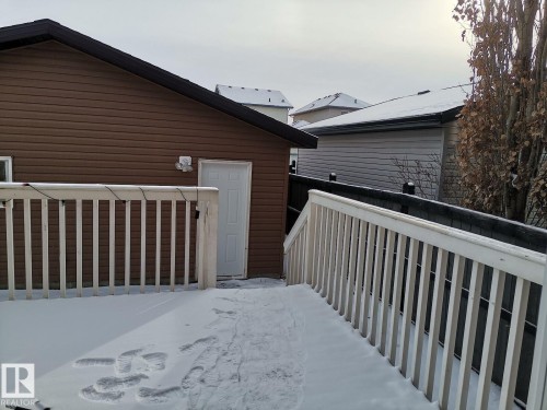 The property features a brown-sided exterior with a white door and a white railing - 115 Keystone Lane, Leduc, AB - Outdoor With Exterior