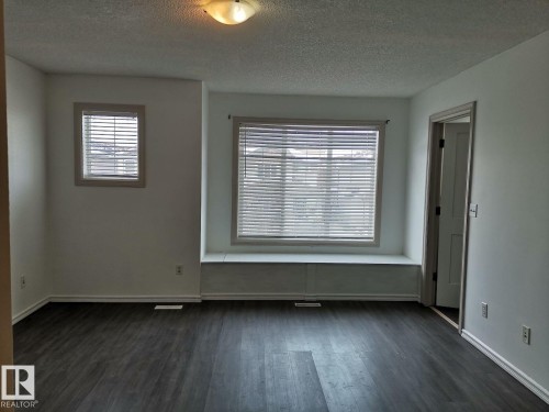 Living space featuring dark wood-look flooring, light-colored walls, and a built-in window seat - 115 Keystone Lane, Leduc, AB - Indoor Photo Showing Other Room