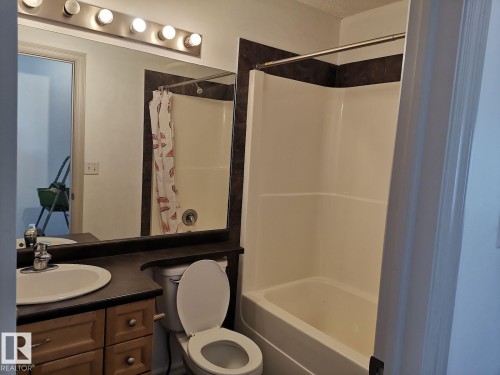 This bathroom features a vanity with a sink, a toilet, a mirror, and a shower/tub combination - 115 Keystone Lane, Leduc, AB - Indoor Photo Showing Bathroom