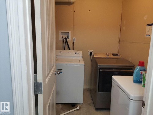 Utility area featuring a top-loading washing machine and a front-loading dryer - 115 Keystone Lane, Leduc, AB - Indoor Photo Showing Laundry Room