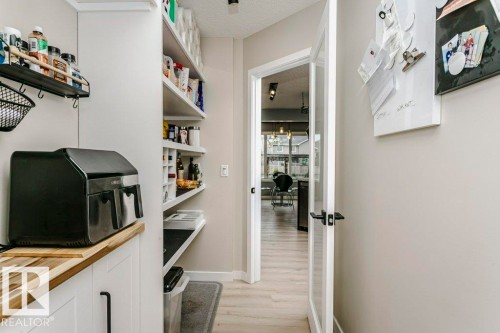 Functional pantry featuring built-in shelving, white cabinetry with black hardware, and wood-finish countertops - 42 Santana Crescent, Fort Saskatchewan, AB - Indoor Photo Showing Other Room