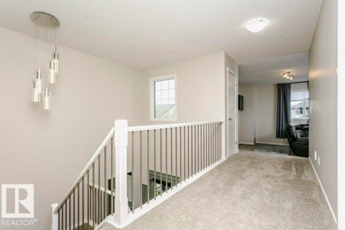 Carpeted hallway with a white baluster railing and brushed metal spindles - 42 Santana Crescent, Fort Saskatchewan, AB - Indoor Photo Showing Other Room