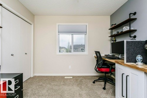 Built-in desk with a wood-finish countertop and white cabinetry - 42 Santana Crescent, Fort Saskatchewan, AB - Indoor Photo Showing Office