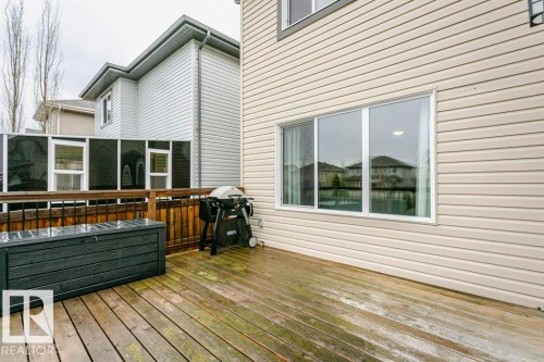 Exterior deck with wood-finish flooring, featuring a black metal railing and privacy screening - 42 Santana Crescent, Fort Saskatchewan, AB - Outdoor With Deck Patio Veranda With Exterior