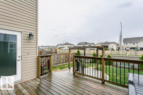 Spacious outdoor deck with wood-finish flooring and black metal railings - 42 Santana Crescent, Fort Saskatchewan, AB - Outdoor With Deck Patio Veranda With Exterior